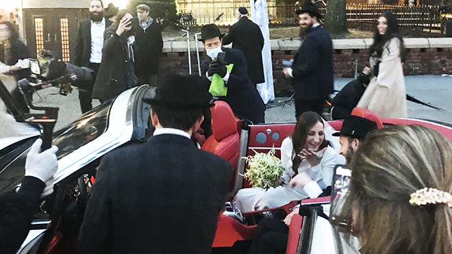 يركب العريس JJ Deitch وزوجته فريدا في علبة مكشوفة حيث يتجمع الناس لحفل زفافهم في بروكلين